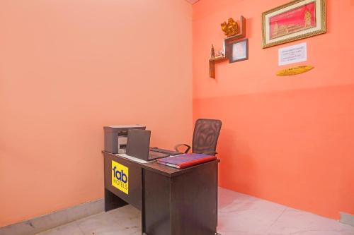 an orange office with a desk with a computer on it at FabHotel Baba Guest House in Varanasi