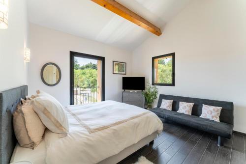 a bedroom with a large bed and a couch at Villa L'ecrin Du Ventoux in Crillon-le-Brave