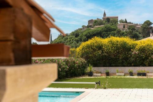 a dog sitting on a bench next to a swimming pool at Villa L'ecrin Du Ventoux in Crillon-le-Brave