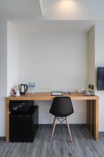 a wooden desk with a black chair in a room at Xinshe Hotel - Hsinchu in Hsinchu City