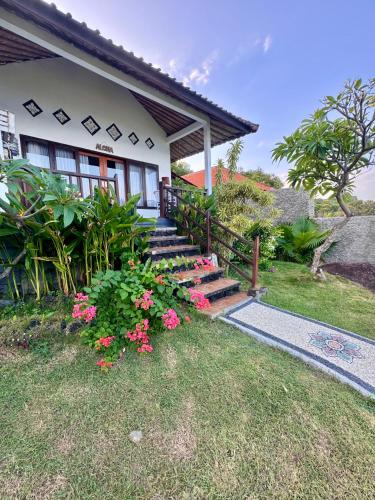 a house with stairs and flowers in front of it at Makawi Tuwa in Seraya