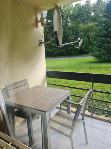 a picnic table and chairs on a porch with a view of a field at Pause Nature N in La Calamine