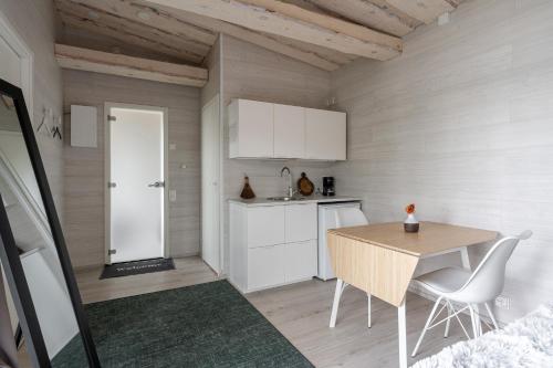 a kitchen with a wooden table and a table and chairs at Private High Quality Suite by the Lakeside in Jyväskylä