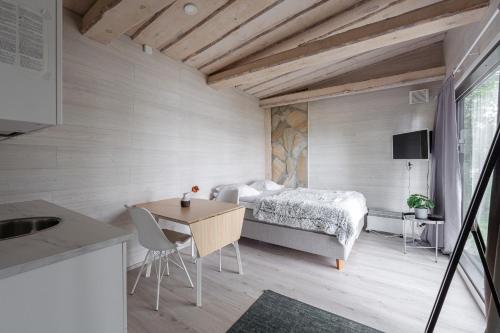 a small bedroom with a bed and a table at Private High Quality Suite by the Lakeside in Jyväskylä