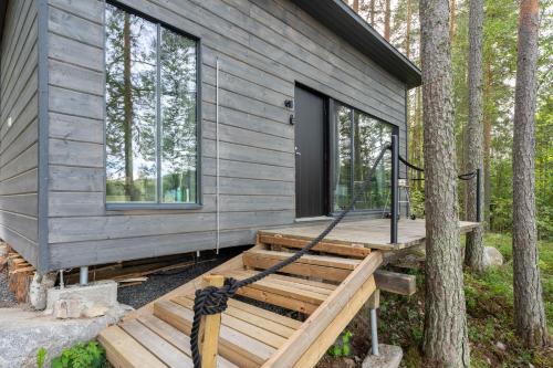 a house with a wooden deck in the woods at Private High Quality Suite by the Lakeside in Jyväskylä