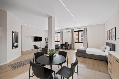 a living room with a bed and a table and chairs at CT Rooms in Nicosia