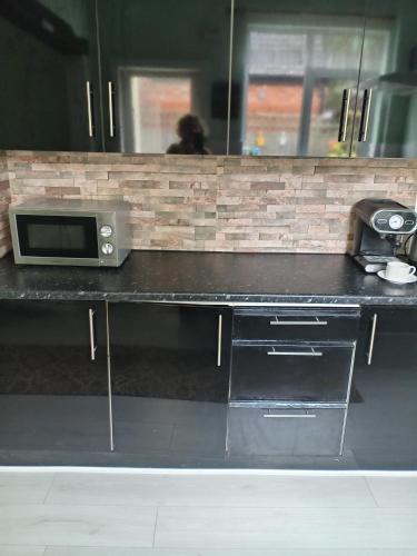 a counter with a microwave on top of it at One bedroom self-catering flat centrally located in Boston