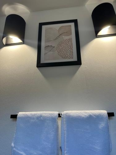two towels are hanging on a wall with two lights at Apartmani Roko in Okrug Donji