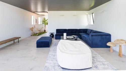 a living room with a blue couch and a table at Villa 4 étoiles en bord de mer - Insolite et Dépaysante in Saint-Jacut-de-la-Mer