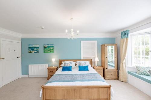 a bedroom with blue walls and a bed with blue pillows at Lonan Country House and Gardens in Taynuilt