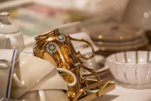 a gold tea cup on a table with dishes at Angiolina's Farm in Levanto
