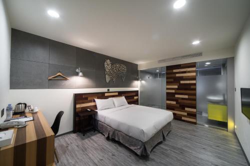 a hotel room with a bed and a desk and a desk at Xinshe Hotel - Hsinchu in Hsinchu City