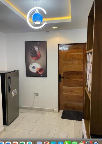 a room with a door and a picture and a refrigerator at Cozy Court Apartment in Ifako