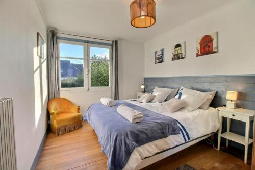 a bedroom with a large bed and a window at Ty Lisa - Maison de village avec véranda lumineuse sur grand jardin in Quiberon