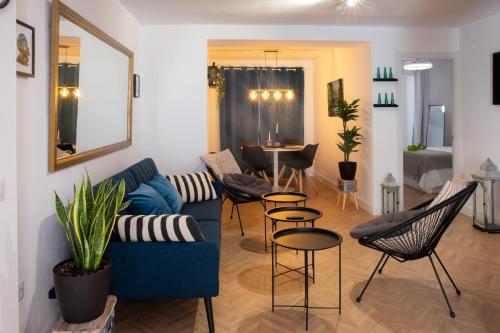 a living room with a blue couch and chairs at La Casa del Gallo Alojamientos by Taberna Bolero in Montilla