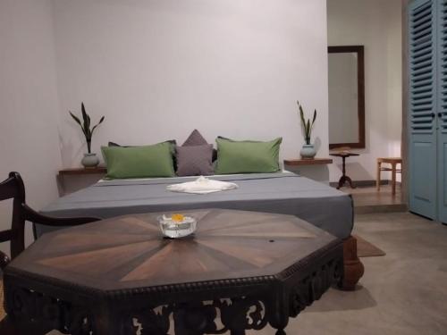 a bed with a table in a room at Inura Villa in Ambalangoda