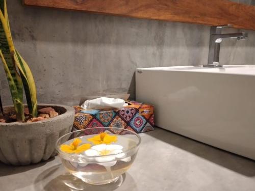 a bowl of flowers on a table next to a sink at Inura Villa in Ambalangoda