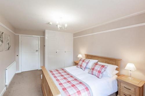 a bedroom with a bed with white sheets and pillows at Lonan Country House and Gardens in Taynuilt