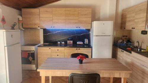 a kitchen with a wooden table and a refrigerator at Cheap & Good by Topo in Tirana