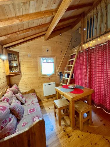 a living room with a table and a couch in a cabin at La Cabane à l'Orée des Bornes in Évires