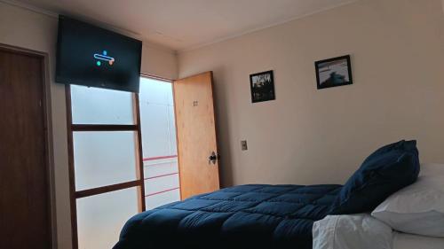 a bedroom with a bed and an open door at Lodge Atacama Hostal in Copiapó