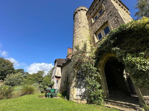 an old stone house with an ivy covered entrance at Quirky Castle on a lake in East Sussex in Mayfield