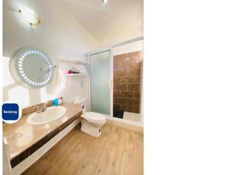 a bathroom with a sink and a toilet and a mirror at Casa 3 Bugambilia de Villa Verde in Chiquimula