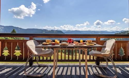 a table and chairs on a deck with a view at Chalet spacieux à Saint-Nicolas-la-Chapelle avec cheminée in Saint-Nicolas-la-Chapelle