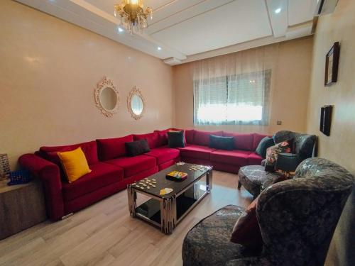 a living room with a red couch and chairs at Beautiful 2 bedrooms apartment in Agadir