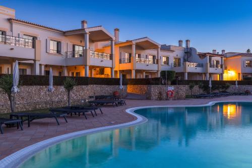 a resort with a swimming pool and some buildings at NAU Salema Beach Village in Salema