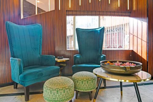 a lobby with two chairs and a bowl on a table at FabHotel Samrat in Kolkata