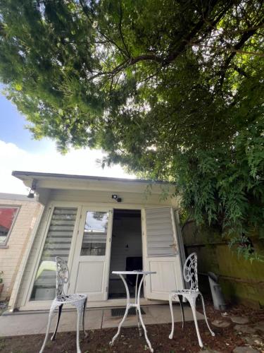 two white chairs sitting in front of a house at 29 Park Avenue , Shoreham-by-Sea , Cozy Cabin in Shoreham-by-Sea