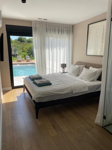 a bedroom with a bed and a large window at Like a therapy VILLA in Krčedin