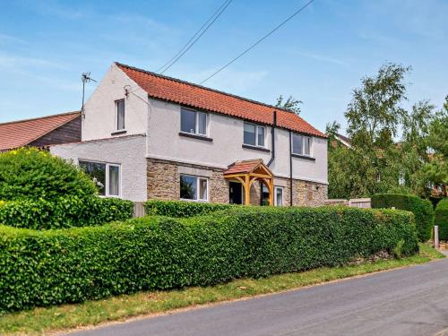 a house with a hedge in front of a street at 2 Bed in Kirkbymoorside 92635 in Kirkbymoorside