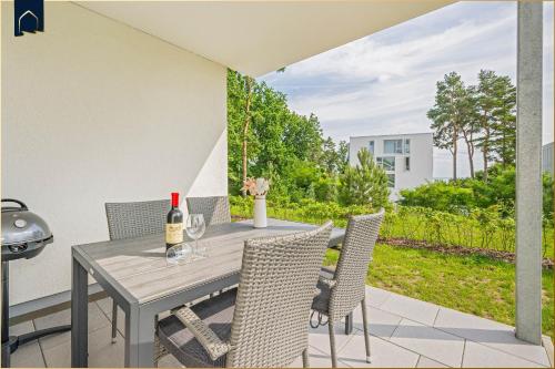 a table with chairs and a bottle of wine on a patio at An der Haffküste Haffkoje in Zirchow