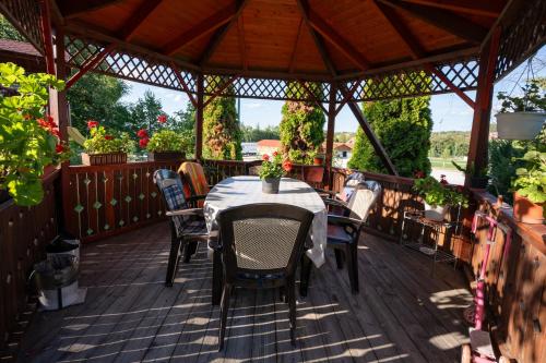 a wooden deck with a table and chairs on it at Hegyi Panzió in Szilvásvárad