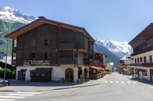 a building on the side of a street with mountains at Résidence Le Cristal Apartments in Chamonix-Mont-Blanc