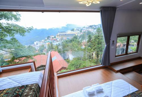 a room with two beds and a large window at Sapa Succulent Garden Homestay in Sa Pa
