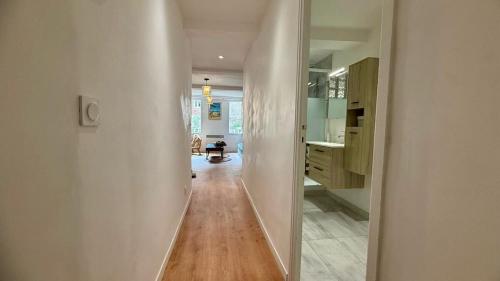 Un pasillo que conduce a una habitación con cocina y un pasillo. en Les Templiers - Downtown and private garage, en Hyères