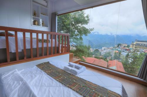 a bedroom with a bed and a large window at Sapa Succulent Garden Homestay in Sa Pa