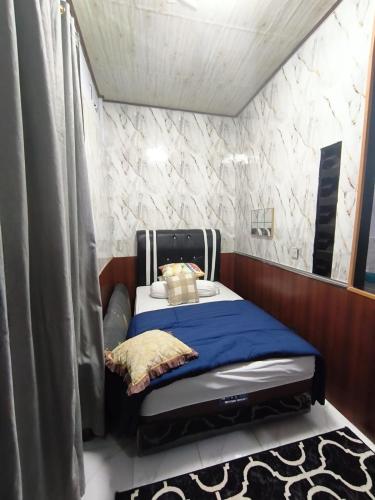 a small bedroom with a bed in a room at Bellezza Kost in Curup