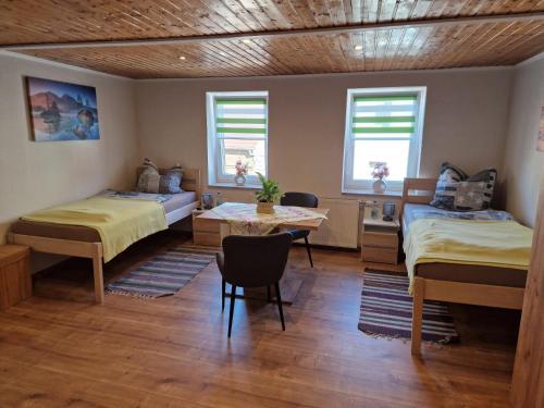 a bedroom with two beds and a table in it at Wieprecht`s Vermietung in Deutsches Haus