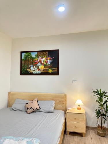 a bedroom with a bed and a painting on the wall at DK2 Homestay in Hanoi