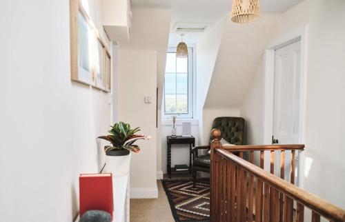a hallway with a staircase with a potted plant at Tigh na Bruthaich in Stenscholl