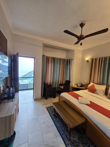 Una habitación de hotel con una cama y una ventana grande. en T&J Villa Mussoorie, en Mussoorie