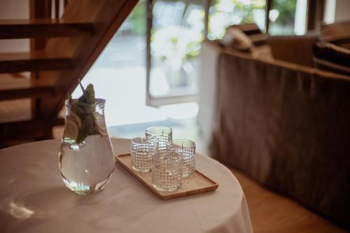 a table with glasses and a vase on a tray at Dom Puchacza w Lądku-Zdroju in Lądek-Zdrój