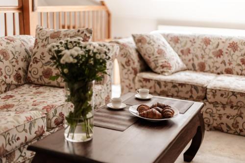 a living room with a couch and a table with a vase of flowers at Dom Puchacza w Lądku-Zdroju in Lądek-Zdrój