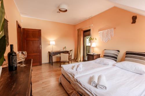 a bedroom with a large bed with white sheets at Dom Puchacza w Lądku-Zdroju in Lądek-Zdrój