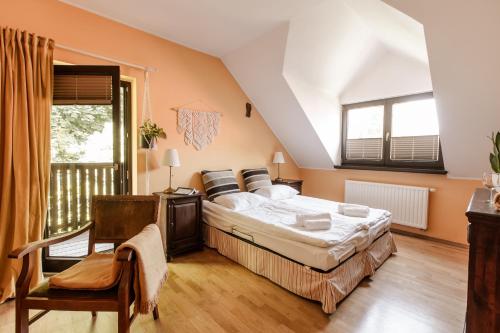 a bedroom with a large bed and a chair at Dom Puchacza w Lądku-Zdroju in Lądek-Zdrój