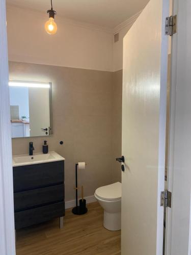 a bathroom with a toilet and a sink and a mirror at Sea La Vie Apartment Porto Santo in Porto Santo